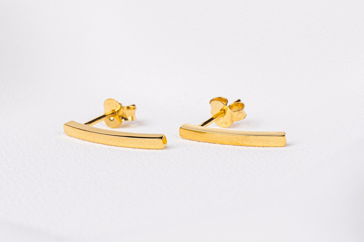 A pair of gold stud earrings with butterfly backs, displayed on a white surface.