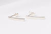 A pair of sterling silver stud earrings with butterfly backs, displayed on a white surface.