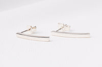 A pair of sterling silver stud earrings with butterfly backs, displayed on a white surface.