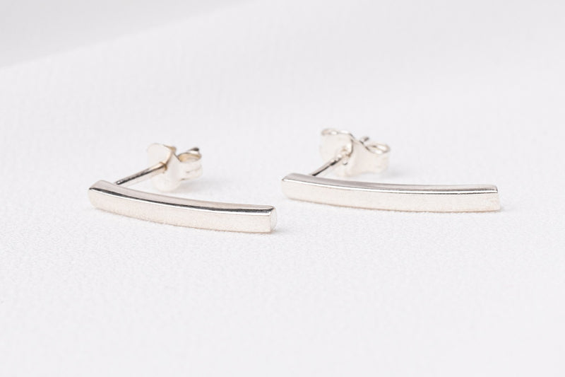 A pair of sterling silver stud earrings with butterfly backs, displayed on a white surface.