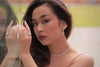 A silver earring with a white pearl worn by a woman