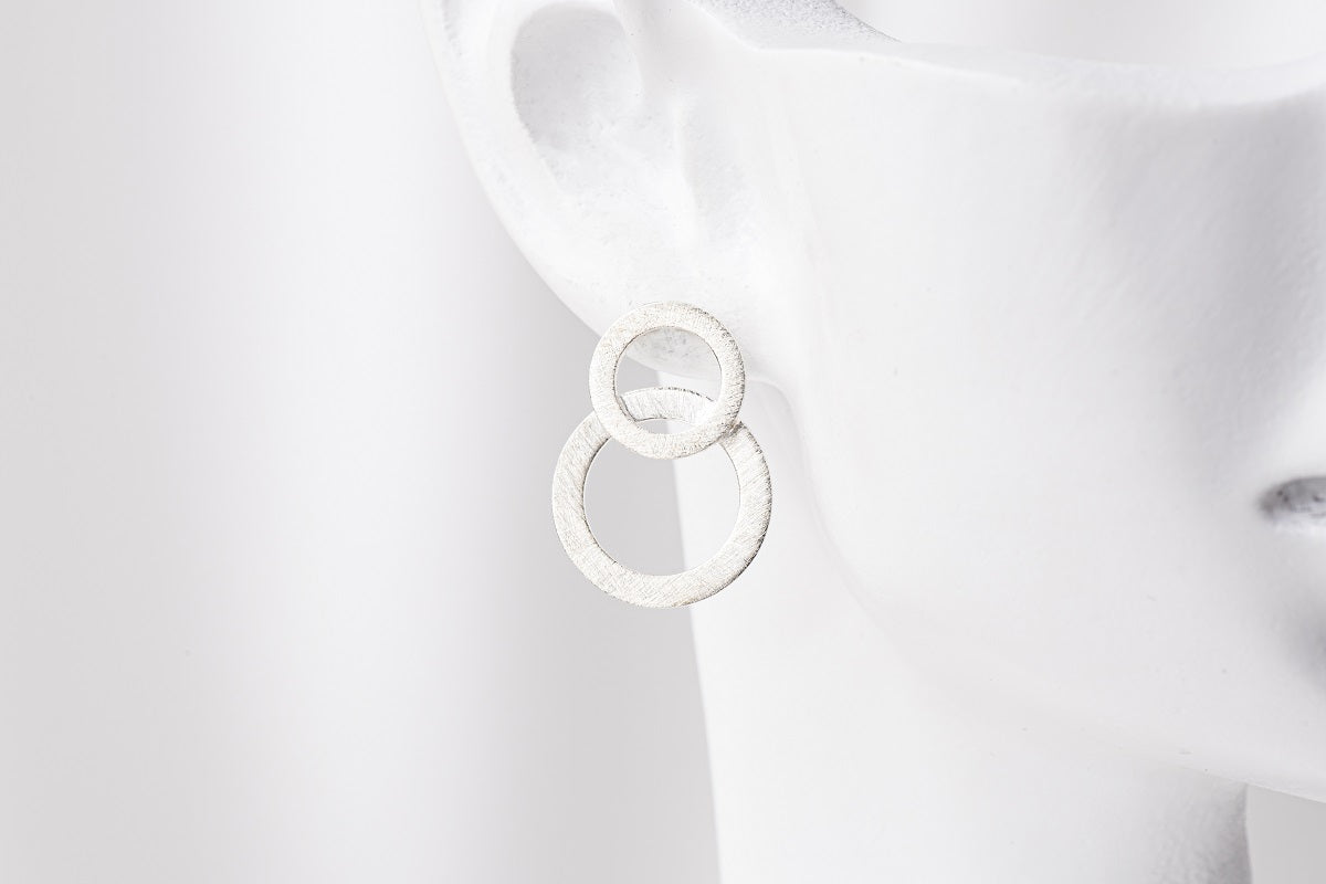Matte silver 8 shaped stud earring on a mannequin head