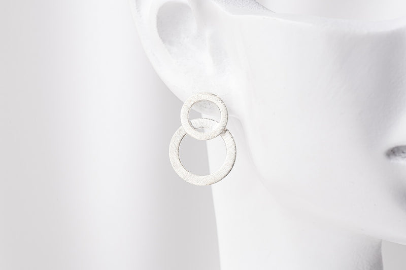 Matte silver 8 shaped stud earring on a mannequin head
