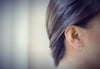 Matte silver 8 shaped stud earring on a model