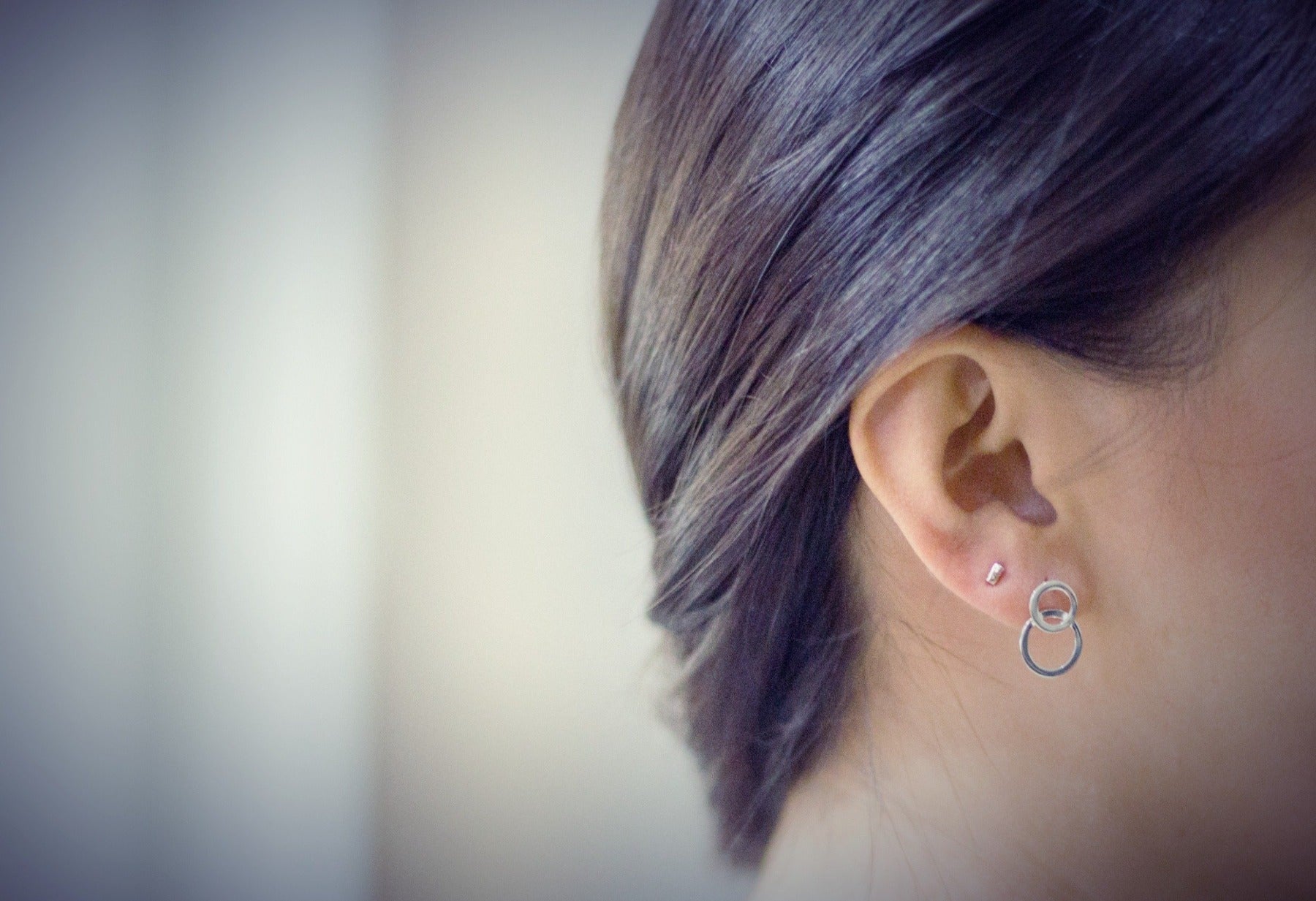 Matte silver 8 shaped stud earring on a model