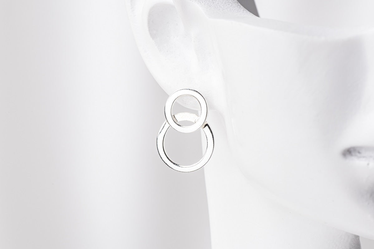 Silver 8 shaped stud earring on a mannequin head