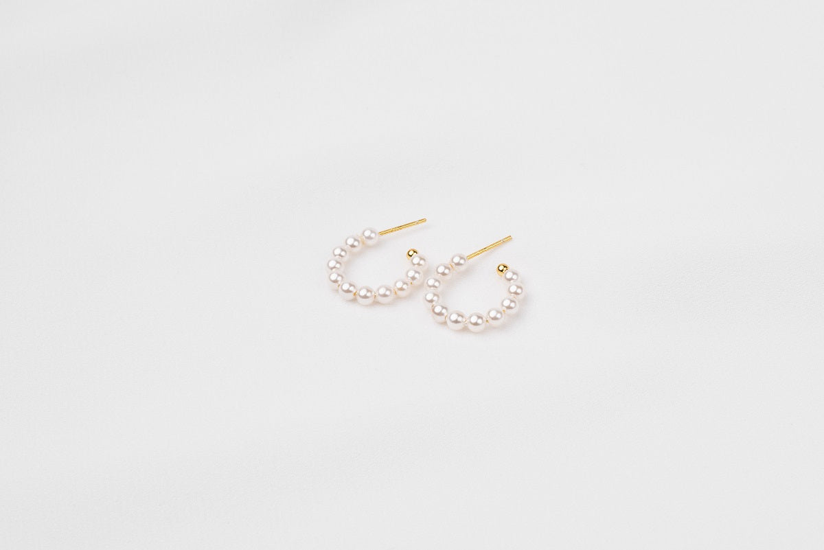 A pair of gold vermeil pearl earrings with a semi-dangle design on a white background.