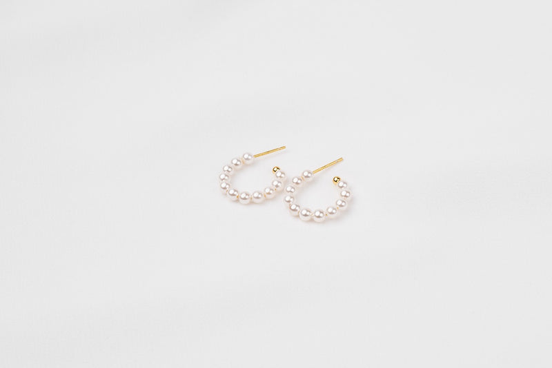 A pair of gold vermeil pearl earrings with a semi-dangle design on a white background.
