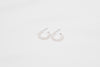 A pair of silver pearl earrings with a semi-dangle design on a white background.