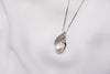 A freshwater pearl necklace with cubic zirconia stone displayed on a white background.