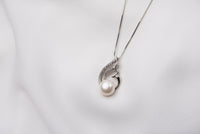 A freshwater pearl necklace with cubic zirconia stone displayed on a white background.