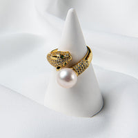 A gold panther design ring on a cone stand with a pearl centerpiece.