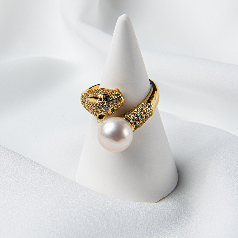 A gold panther design ring on a cone stand with a pearl centerpiece.