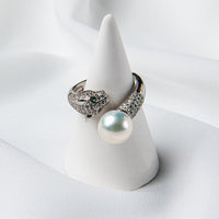A silver panther design ring on a cone stand with a pearl centerpiece.