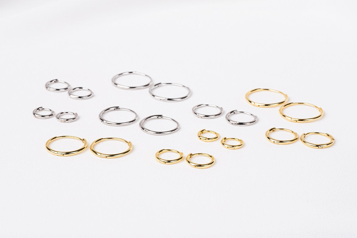A collection of plain huggie earrings in sterling silver, displayed in various sizes with the diameters marked.