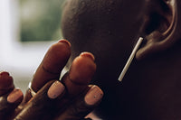 A pair of silver long bar stud earrings on a woman model