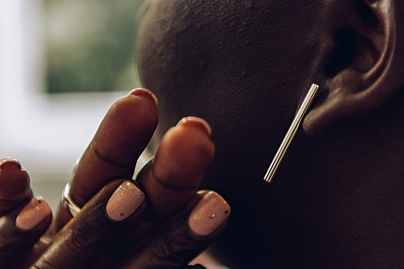 A pair of silver long bar stud earrings on a woman model