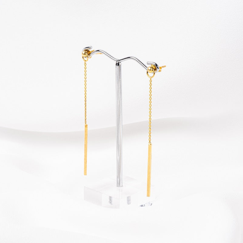A pair of gold-colored dangle earrings with butterfly backs, displayed against a white background.
