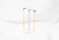 A pair of gold-colored dangle earrings with butterfly backs, displayed against a white background.