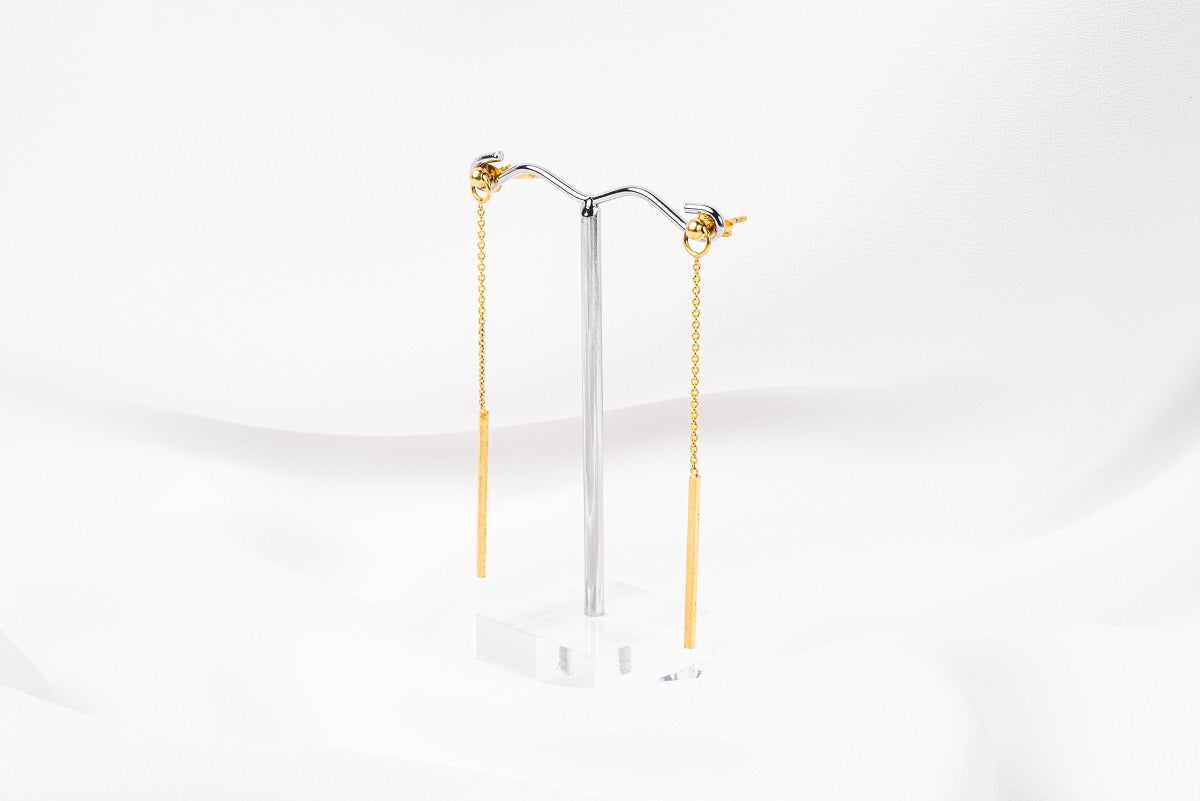 A pair of gold-colored dangle earrings with butterfly backs, displayed against a white background.