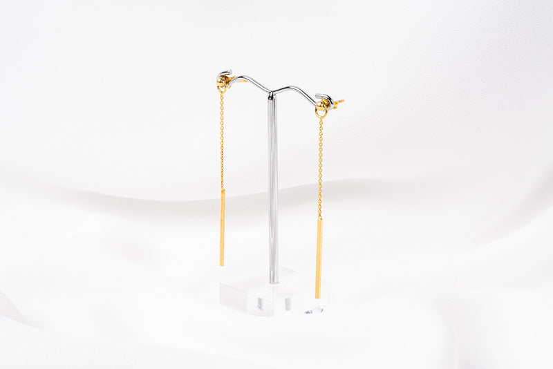 A pair of gold-colored dangle earrings with butterfly backs, displayed against a white background.
