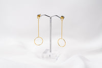 A pair of gold-colored dangle earrings with butterfly backs, displayed against a white background.