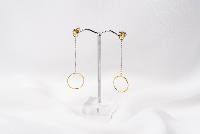 A pair of gold-colored dangle earrings with butterfly backs, displayed against a white background.