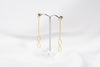 A pair of gold-colored dangle earrings with butterfly backs, displayed against a white background.
