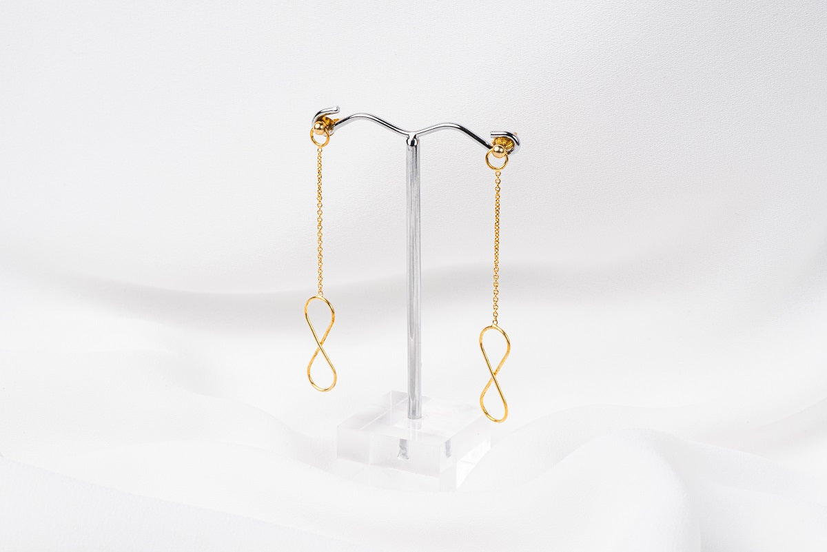 A pair of gold-colored dangle earrings with butterfly backs, displayed against a white background.