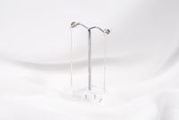 A pair of silver-colored dangle earrings with butterfly backs, displayed against a white background.