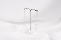 A pair of silver-colored dangle earrings with butterfly backs, displayed against a white background.