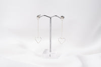 A pair of silver-colored dangle earrings with butterfly backs, displayed against a white background.