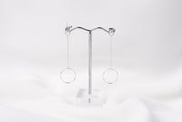 A pair of silver-colored dangle earrings with butterfly backs, displayed against a white background.
