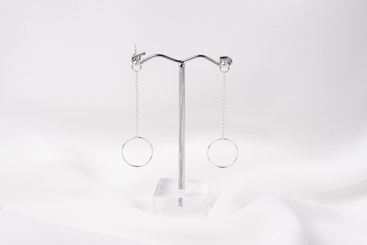 A pair of silver-colored dangle earrings with butterfly backs, displayed against a white background.