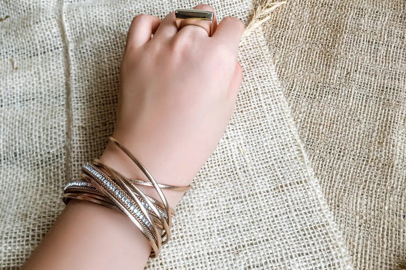 Rose gold bracelet on a model with a canvas background
