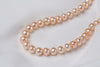 A freshwater champagne pearl necklace displayed on a white background