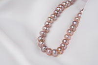 A freshwater lavender pearl displayed on a white background 
