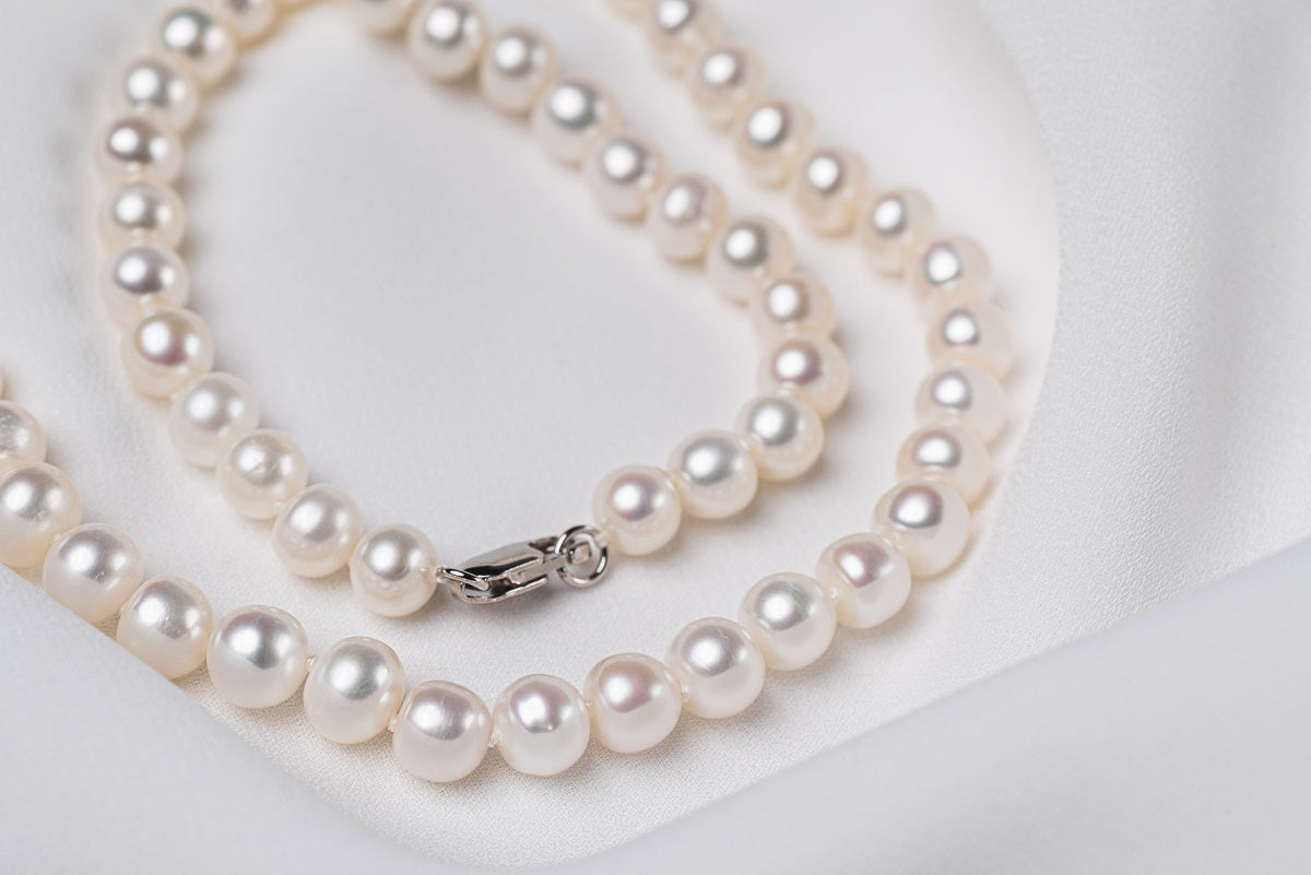 A freshwater white pearl necklace displayed on a white background