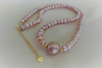 A string of pearls with a larger lavender pearl gold vermeil chain in the center displayed on a white background.