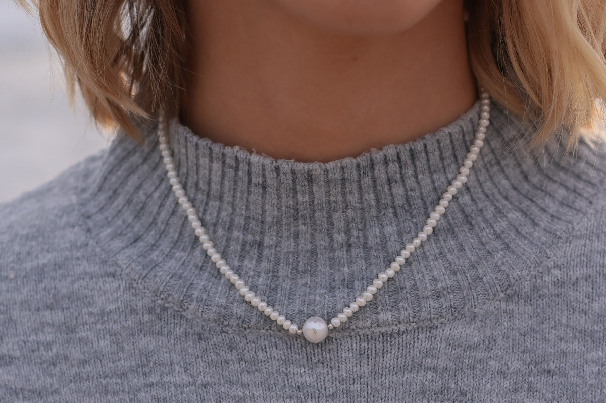 A women wearing a freshwater white pearl necklace