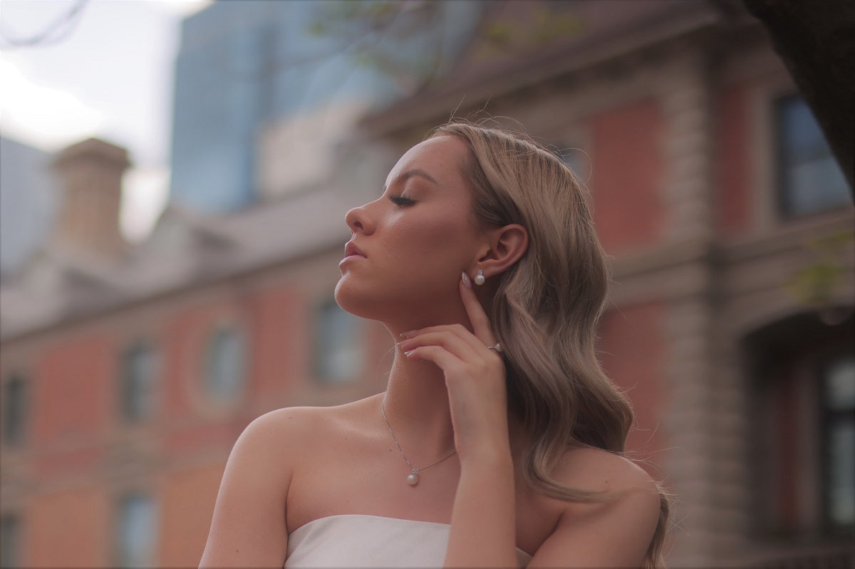 Woman wearing pearl jewellery set with a blurred background