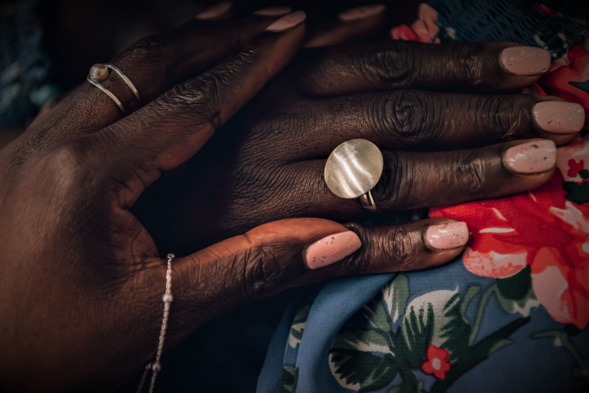 Cloose up of a womans hand wearing a silver button shaped ring