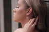 A woman wearing a pearl earrling on a gold vermeil hook