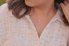 A women wearing a classic white pearl necklace with an adjustable chain and a single pearl pendant.
