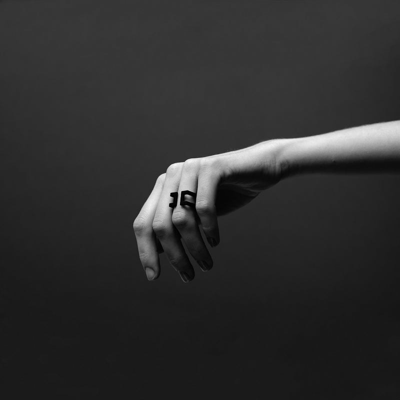 Black and white picture of a hand wearing a black ring
