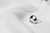 A polished silver ring with a solid pattern, displayed on a white fabric surface.