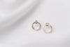 A pair of matte silver stud earrings with a butterfly back design, displayed against a white fabric background.