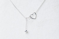 A sterling silver necklace with a double layer design featuring heart-shaped pendants.