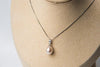 Silver chain necklace with a pearl pendant on a bust
