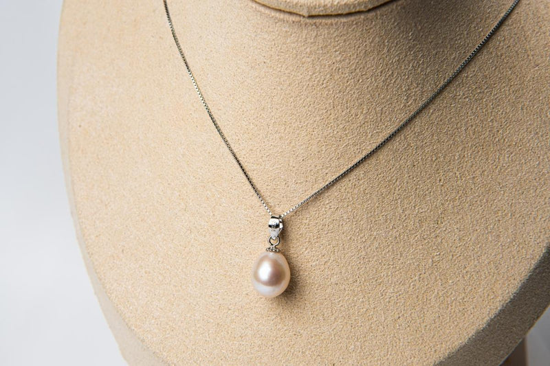 Silver chain necklace with a pearl pendant on a bust
